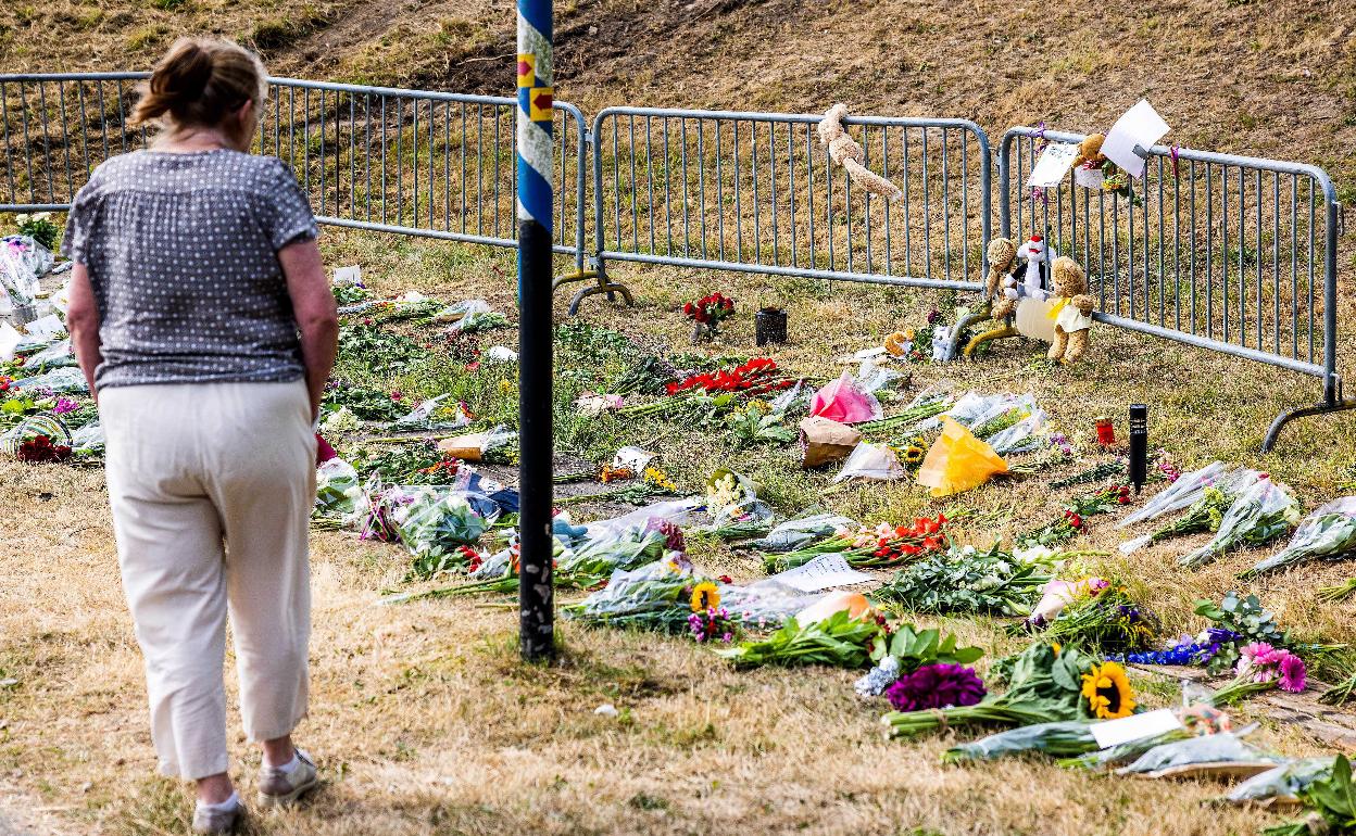 Una mujer deposita flores en el lugar del accidente, en la aldea de Zuidzijde 