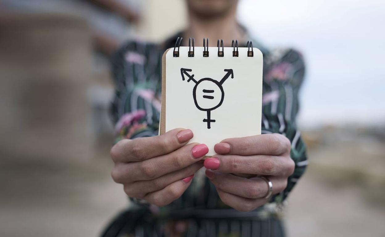 Una mujer muestra el símbolo de la transexualidad. 