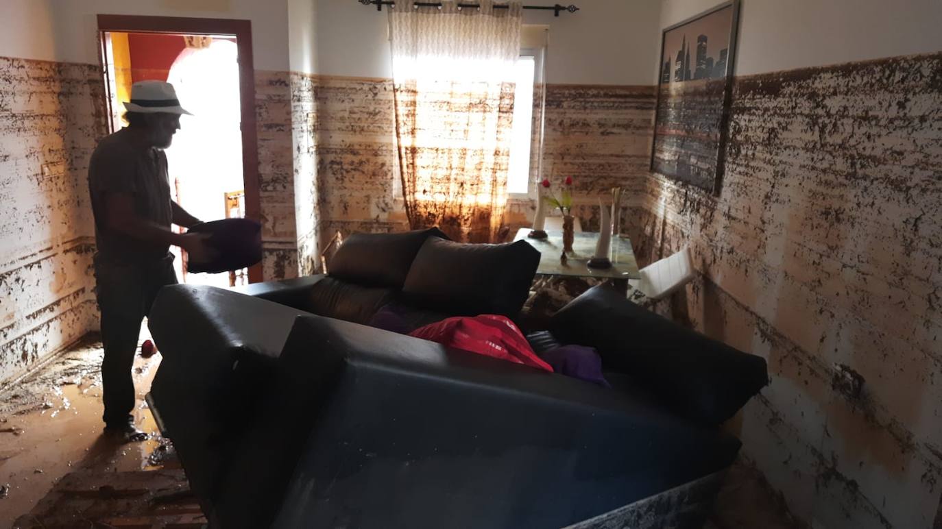 Un hombre achica agua tras las inundaciones en Javalí Viejo.