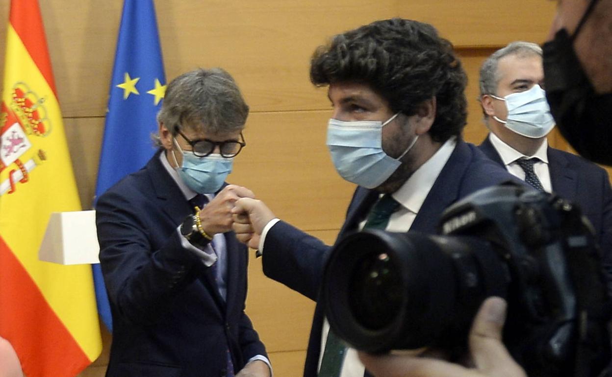 El presidente, Fernando López Miras, y el consejero de Economía y Hacienda, Luis Alberto Marín, chocan sus puños en un gesto de complicidad.