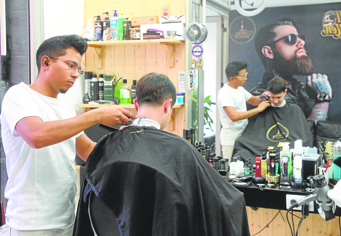 Jordan Calderón atiende a un cliente en El Jordy Barbershop, la barbería que abrió hae un año en la calle Puerta.