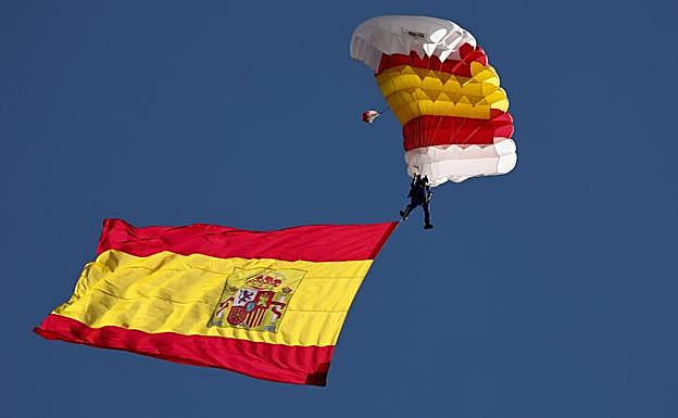 El paracaidista Óscar García, con la bandera de España desplegada en el desfile militar del Día de la Fiesta Nacional. 