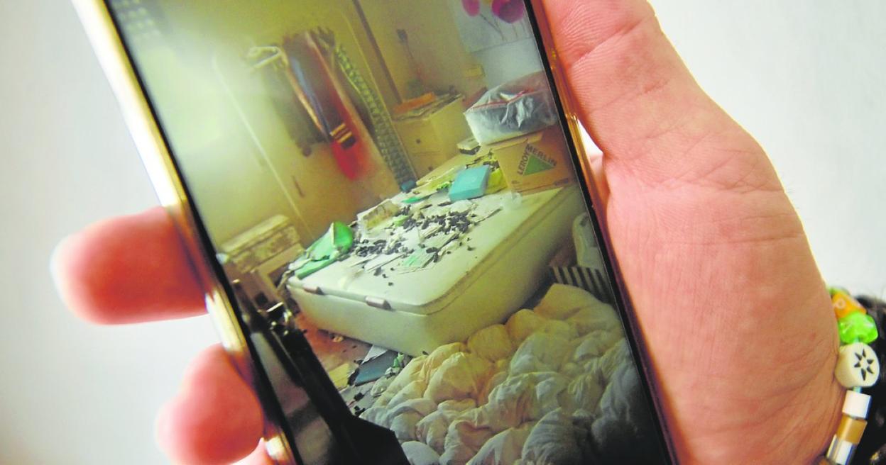 Un vecino muestra una foto en la que se ven heces de animal sobre una cama, en la casa de la mujer. 