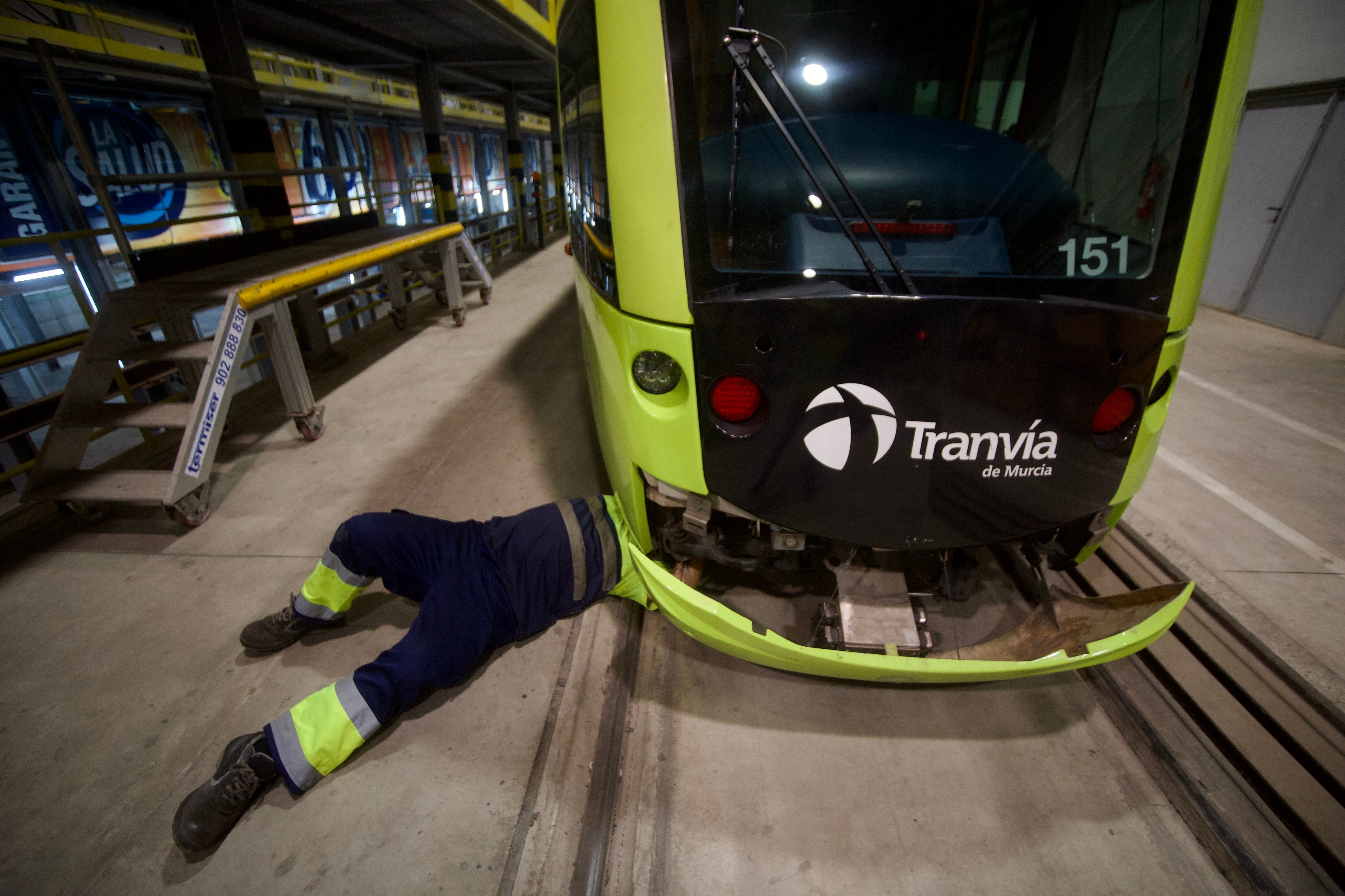 Operarios de Tranvía de Murcia revisan dos vehículos en las instalaciones de La Ladera, uno de ellos, en el foso.