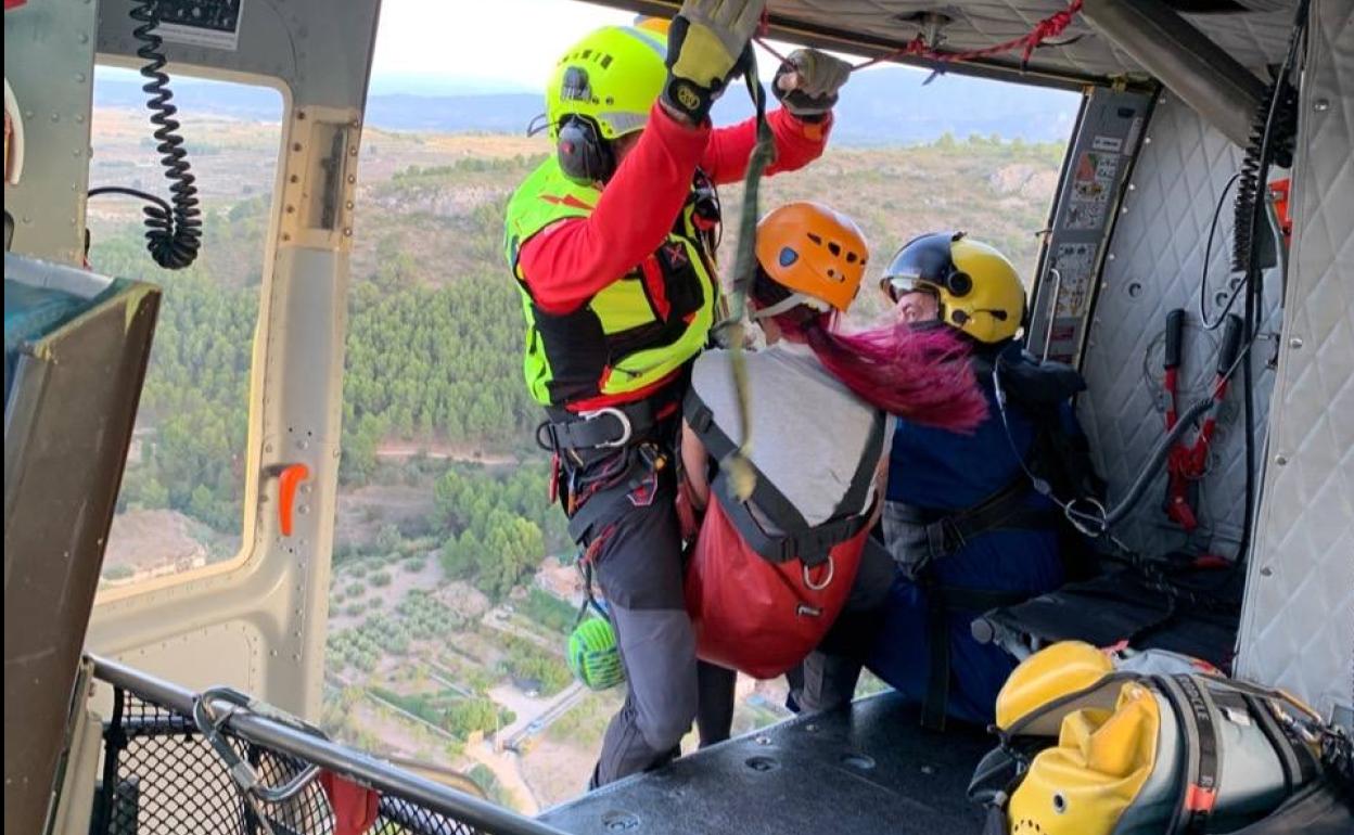 Miembros de la brigada de rescate del CEIS trasladan a la senderista en helicóptero. 