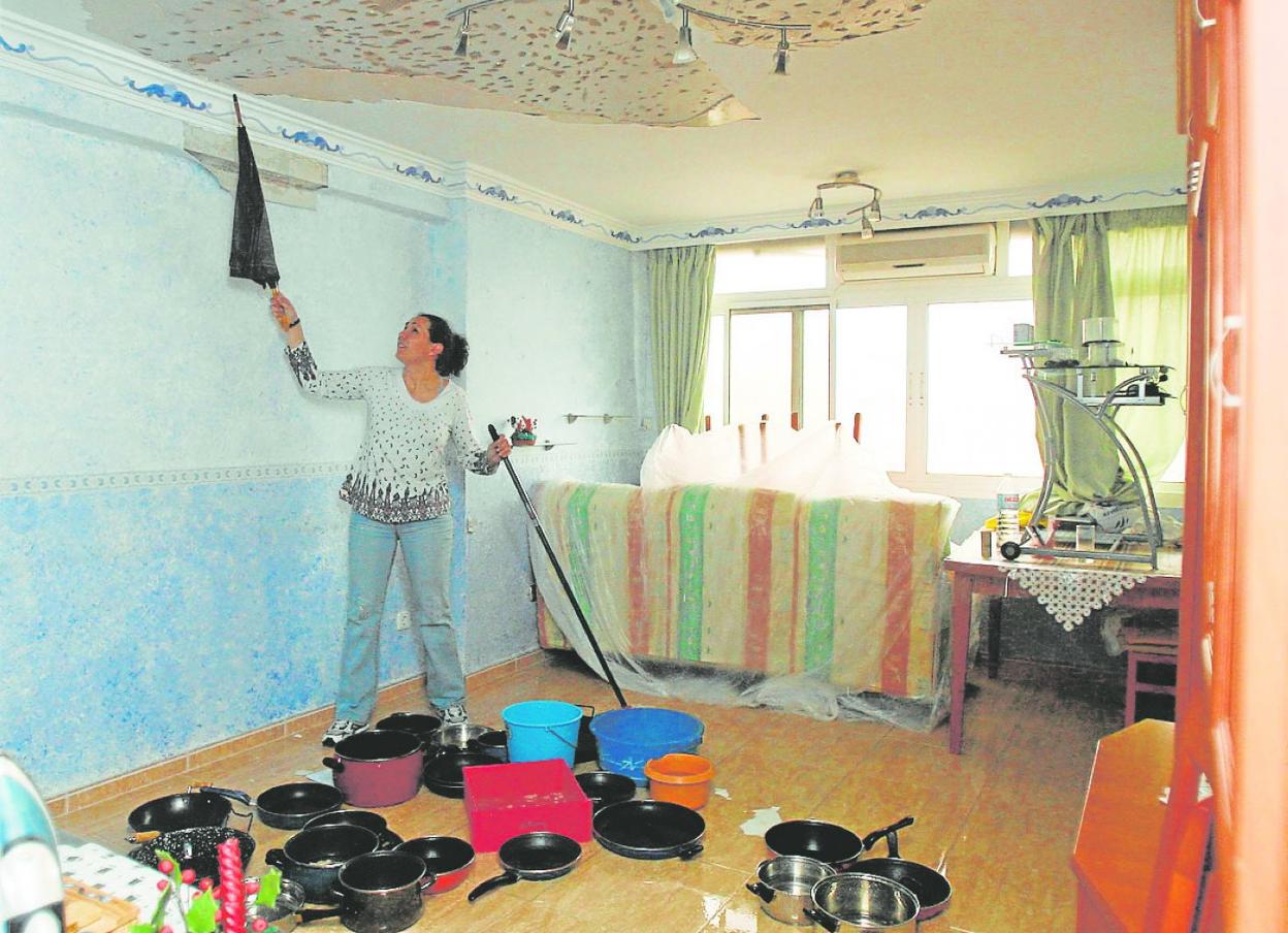 Una mujer ve afectada la sala de estar de su piso por goteras procedentes del vecino de arriba.