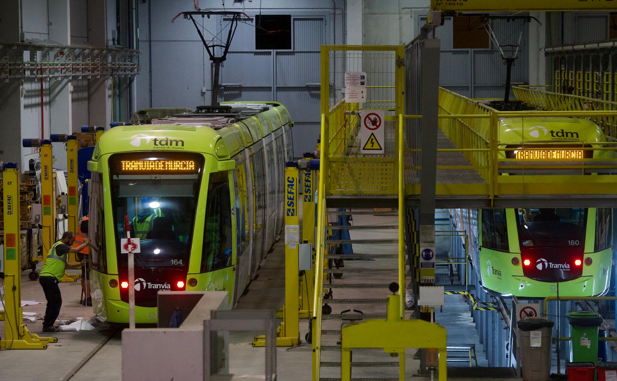Operarios de Tranvía de Murcia revisan dos vehículos en las instalaciones de La Ladera, uno de ellos, en el foso.