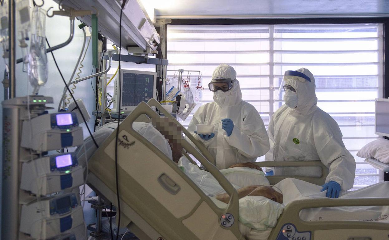 Dos sanitarios atienden a un paciente con coronavirus en el hospital Morales Meseguer de Murcia, en una imagen de archivo. 