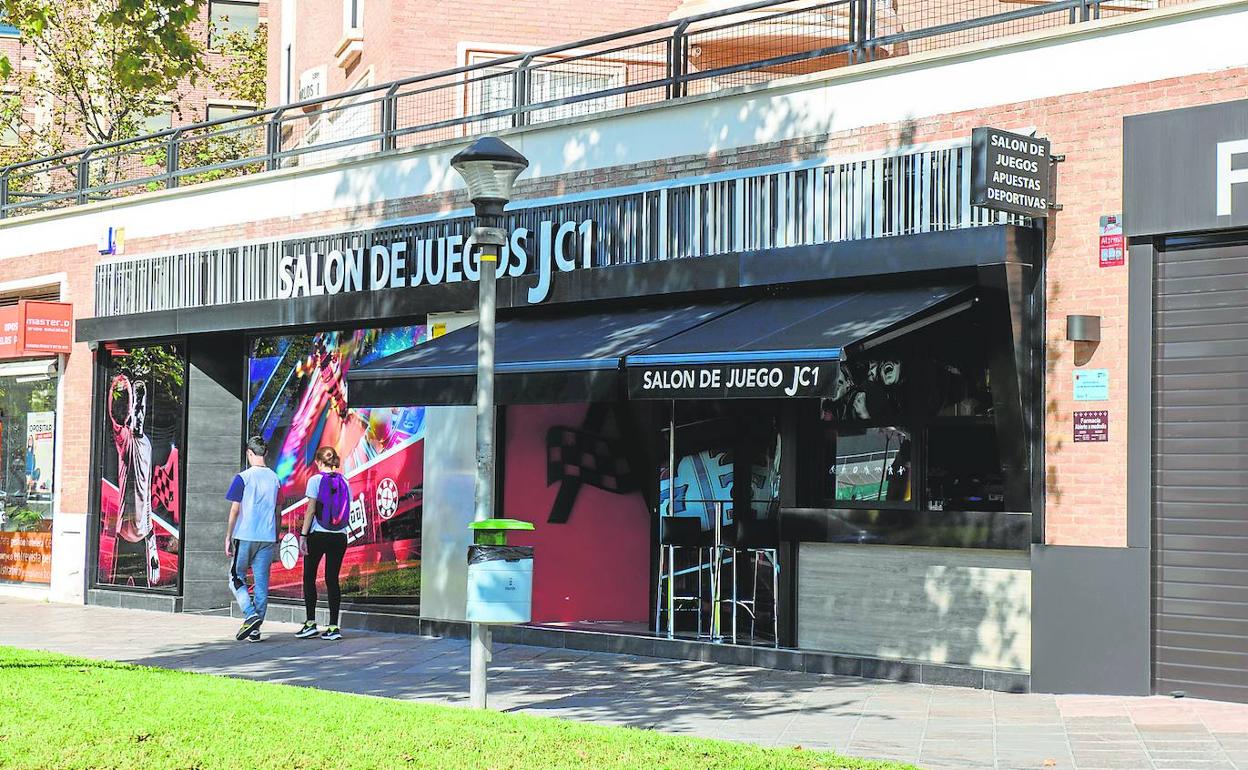 Dos jóvenes pasan por delante de un salón de juegos, ayer, en la avenida Juan Carlos I de la ciudad de Murcia. 