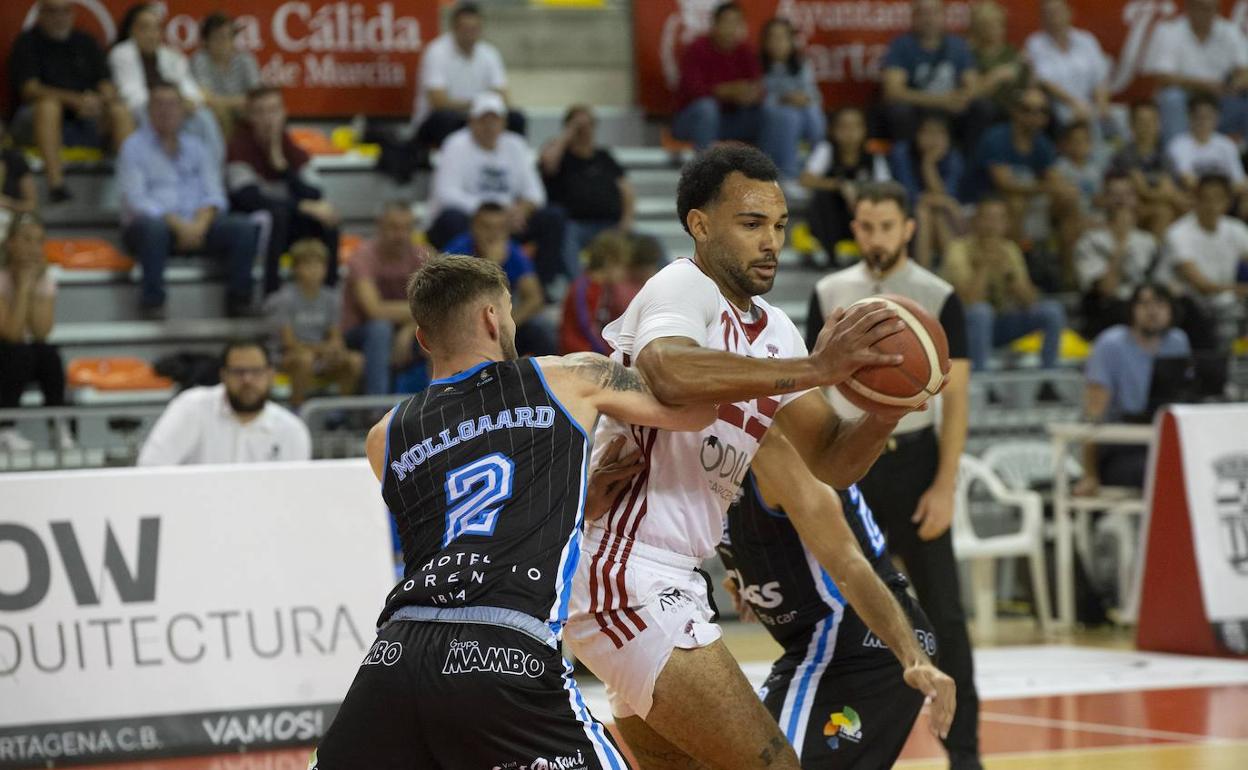 Powell, rodeado de rivales, en el partido de este domingo en el Palacio de Deportes de Cartagena. 