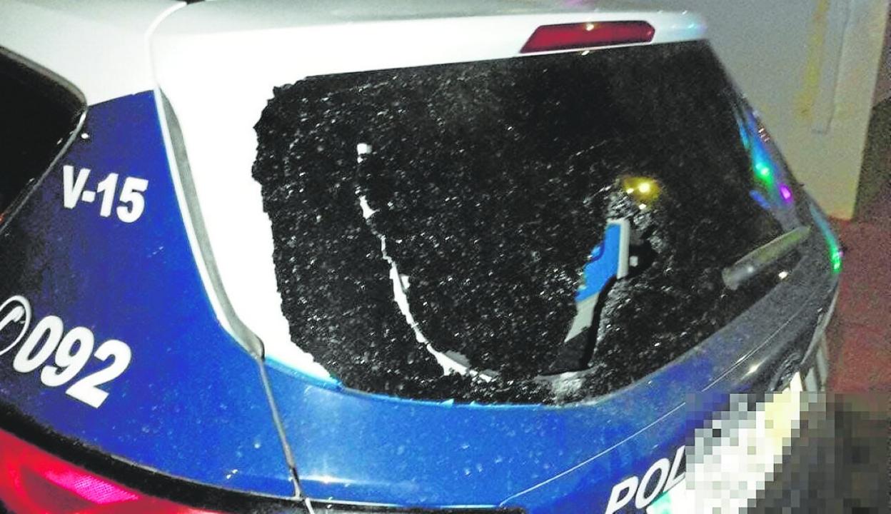Luna de un coche patrulla rota por una pedrada durante la reyerta en una discoteca de Águilas. 
