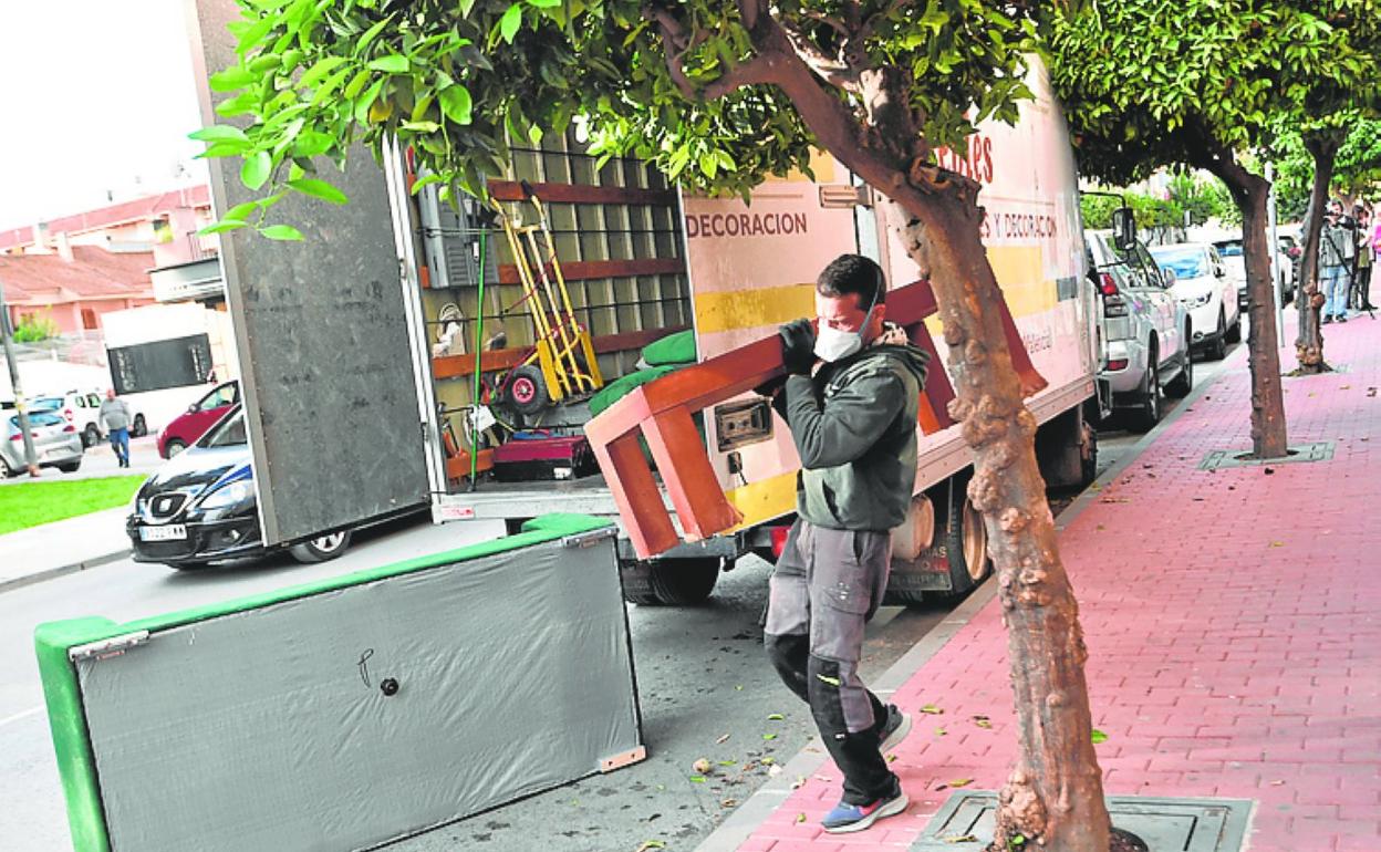 Un trabajador retirando enseres del domicilio, este jueves.