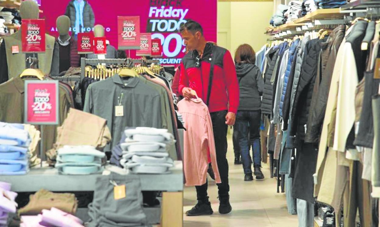 Un joven observa varias prendas rebajadas ayer en el centro de Cartagena. 