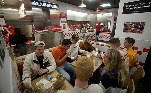 Varios comensales disfrutan de sus hamburguesas en Five Guys. 