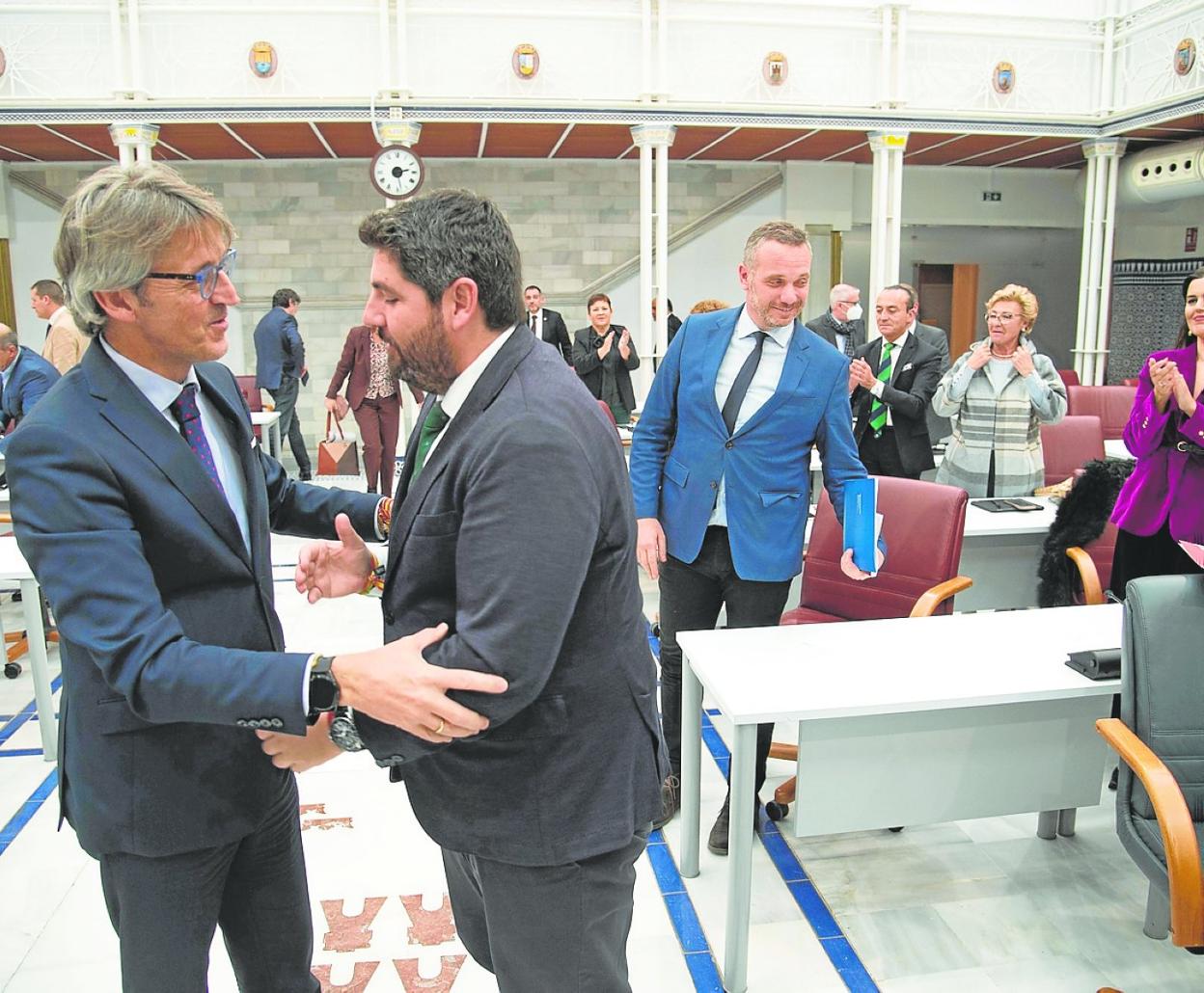 El consejero de Hacienda y el presidente López Miras se saludan en la Asamblea el pasado viernes. 