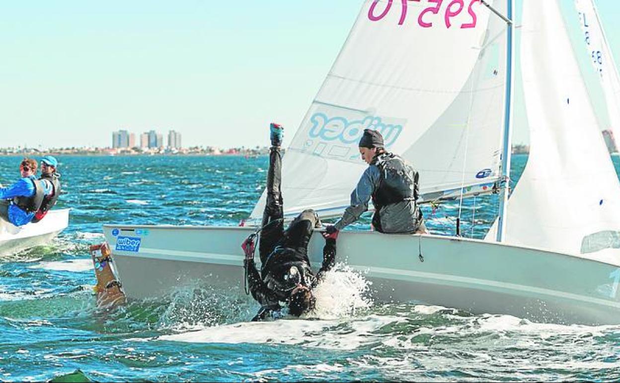 Uno de los regatistas, a punto de caer al agua.