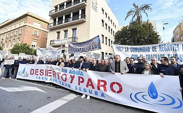 Los represetantes de los regantes y dirigentes empresariales sujetan la pancarta en la concentración junto a la Delegación del Gobierno en Murcia.