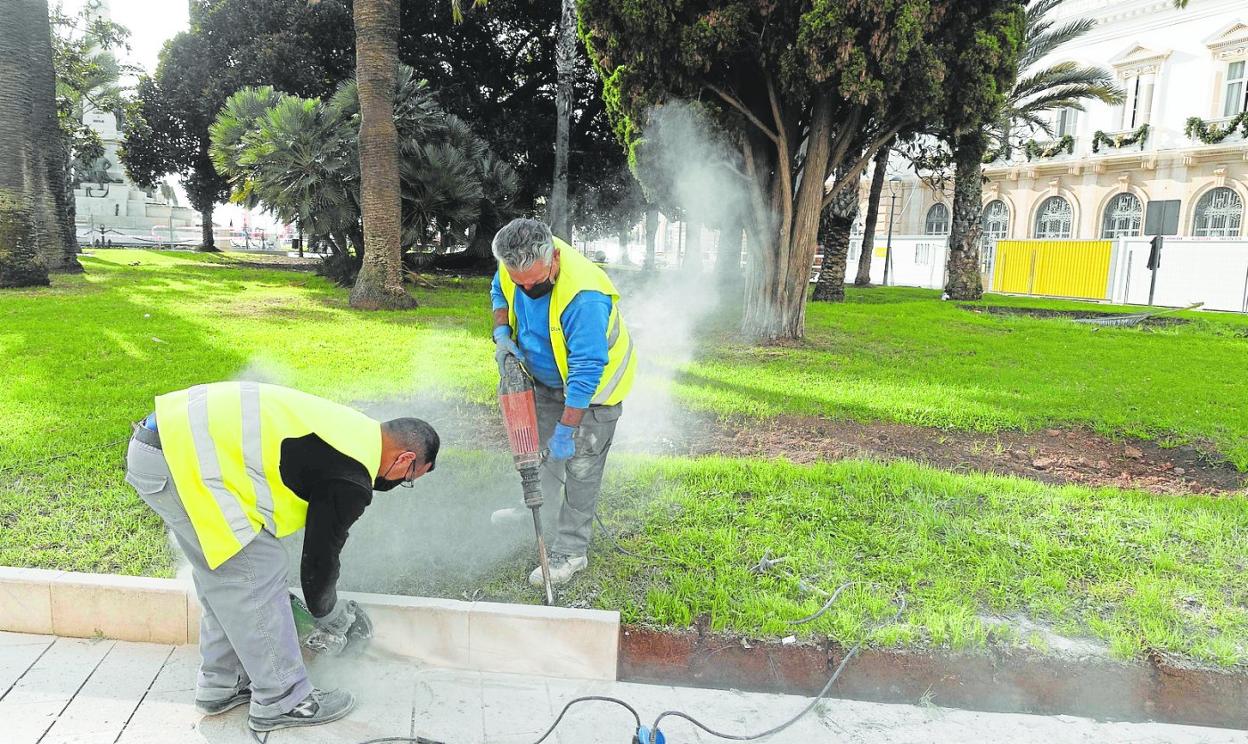 Dos obreros quitan los bordillos de un jardín de la Plaza Héroes de Cavite, junto a la sede de la Autoridad Portuaria. 