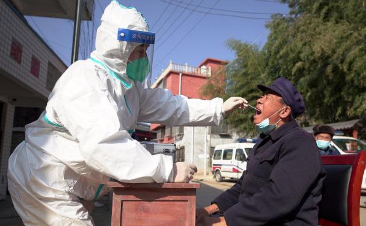 Un sanitario realiza una prueba PCR a un vecino de Danzhai, en la provincia de Guizhou, al suroeste de China. 