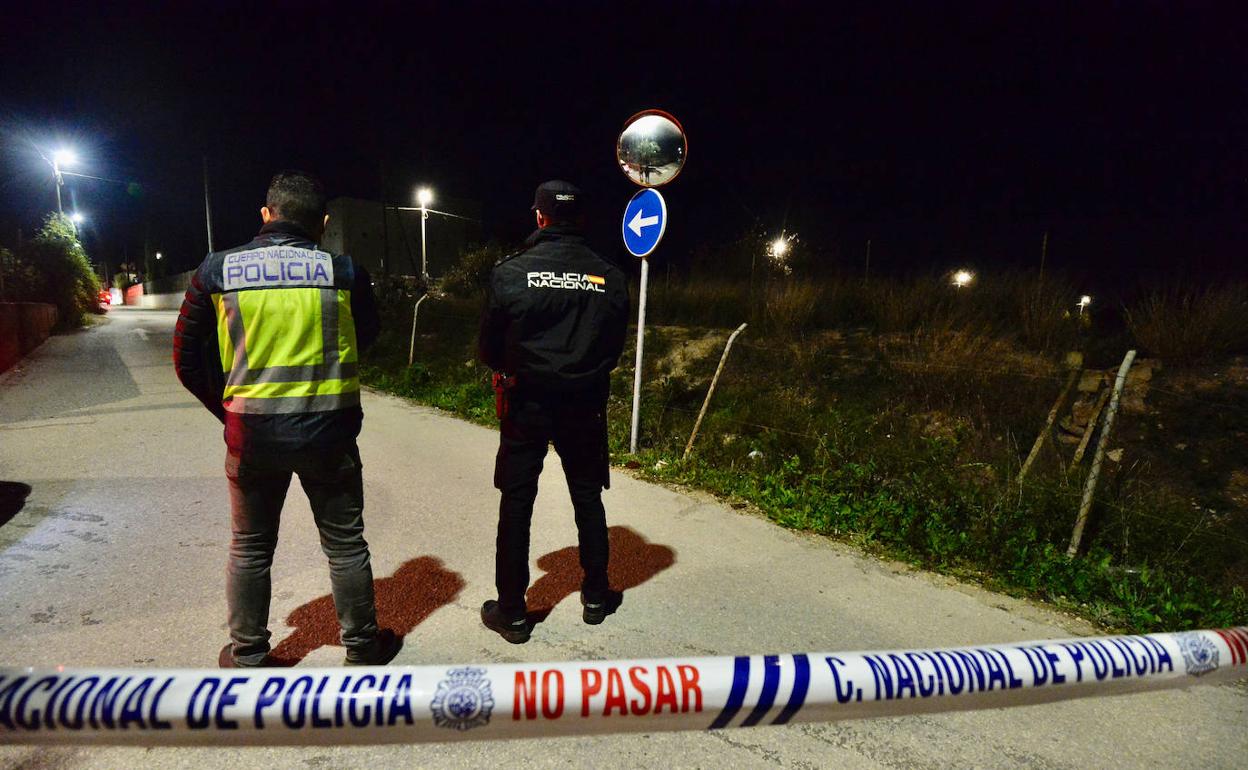 Dos agentes vigilan un área restringida durante una operación policial. 