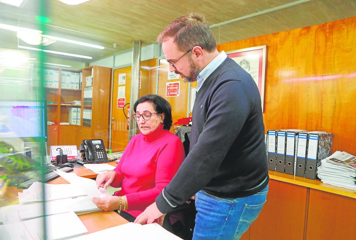 Mateos consulta su agenda de reuniones con vecinos con su secretaria en la alcaldía. 