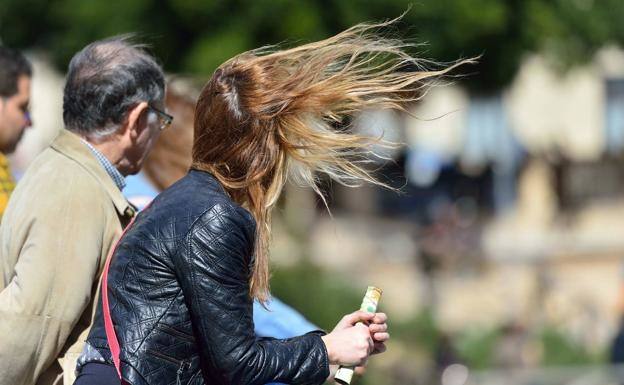 Gente en la calle en un día de viento, imagen de archivo.