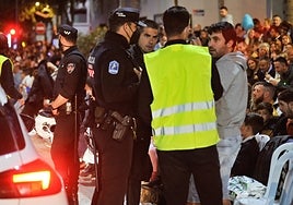 Un policía recibe las quejas de ciudadanos al encontrar ocupadas las sillas que compraron, durante el pasado Entierro de la Sardina.