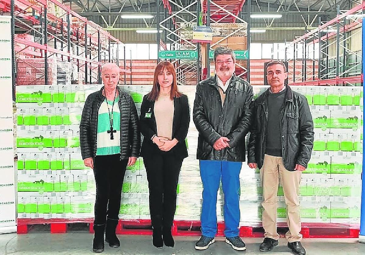 Esther Piornos, de Mercadona, y José García-Galbis, presidente del Banco de Alimentos, junto a otros miembros del mismo, en la entrega de los más de 7.000 litros de leche donados por Mercadona.