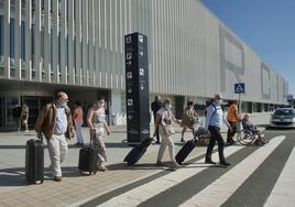 Varios viajeros saliendo del aeropuerto de la Región de Murcia con su maleta, en una imagen de archivo.