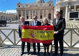 cofrades caravaqueños con una Cruz de Caravaca en una bandera de España.
