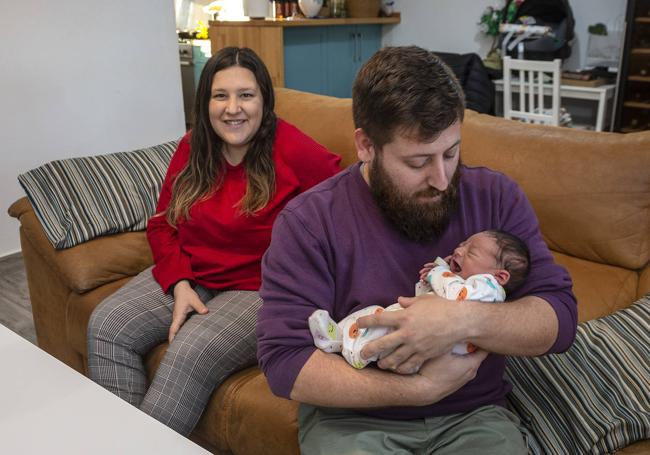 Adrián Cánovas toma a su hijo Óliver en su casa de El Jimenado, junto a su mujer, Irene Gómez.