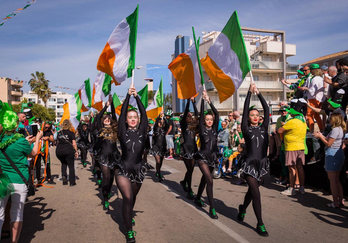 Bailarinas desfilan por Aguamarina con las banderas de Irlanda en alto.