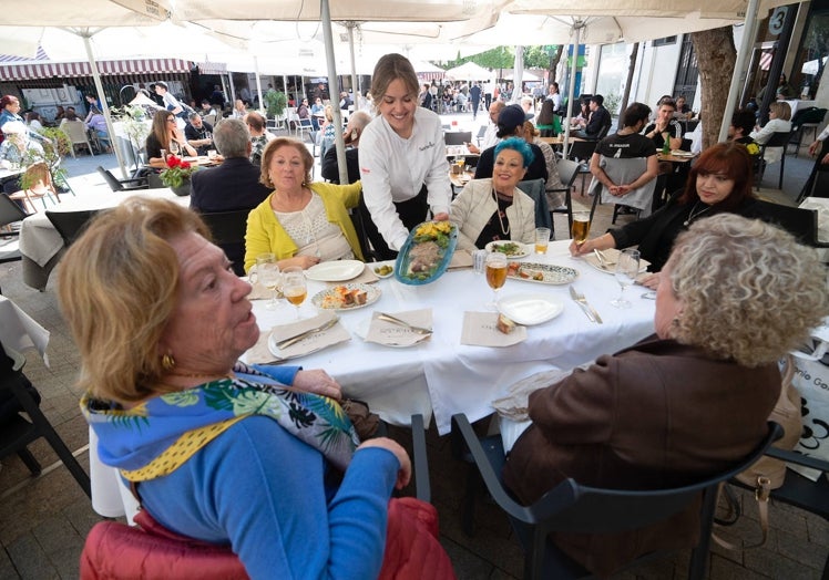 Ana María López sirve un plato en una de la mesas del Salón del Secreto, en la Plaza de las Flores.