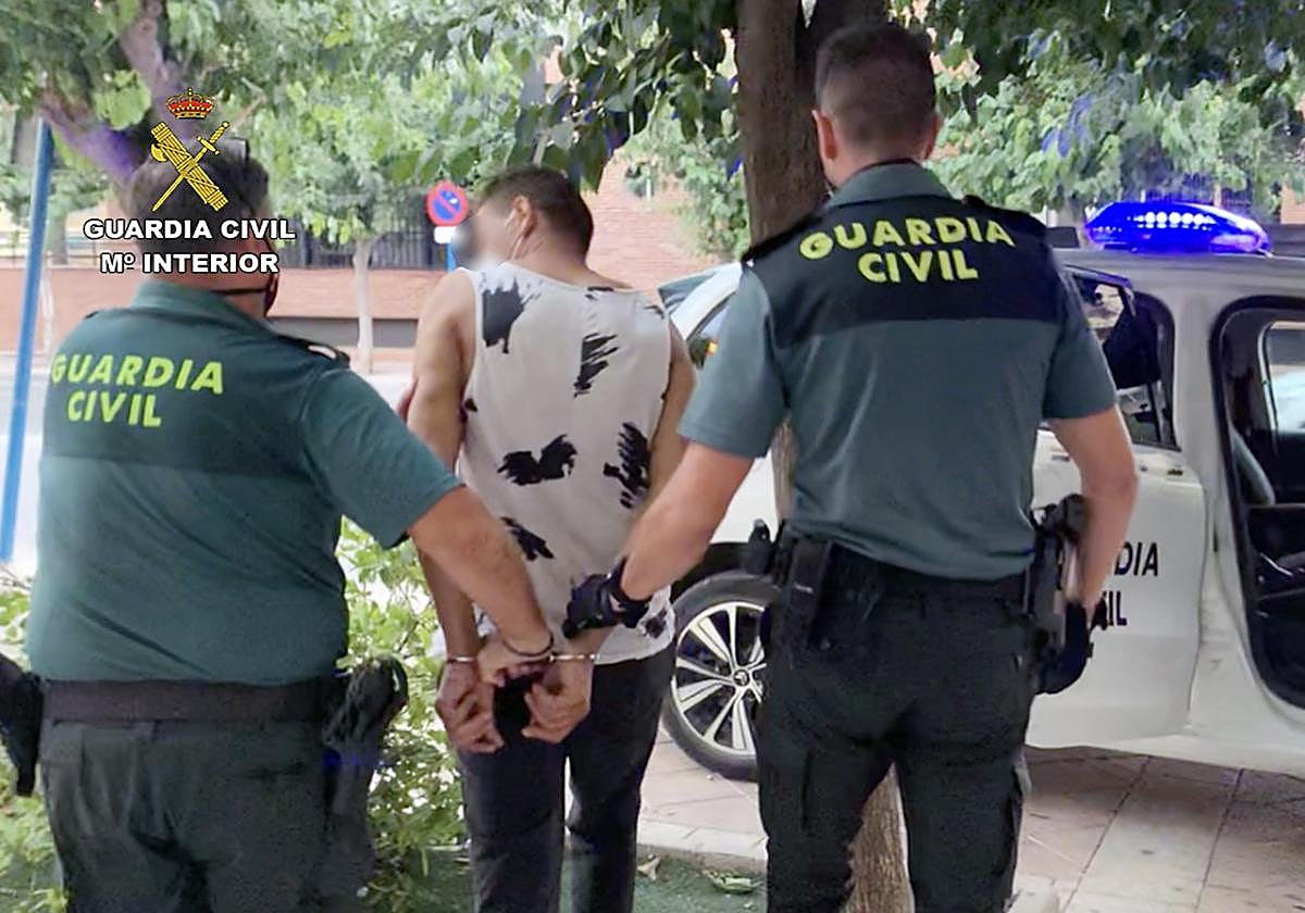 Dos agentes de la Guardia Civil junto al detenido.