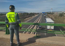 Un guardia civil de la Agrupación de Tráfico observa la autovía A-7 desde el puente junto Estadio Nueva Condomina.