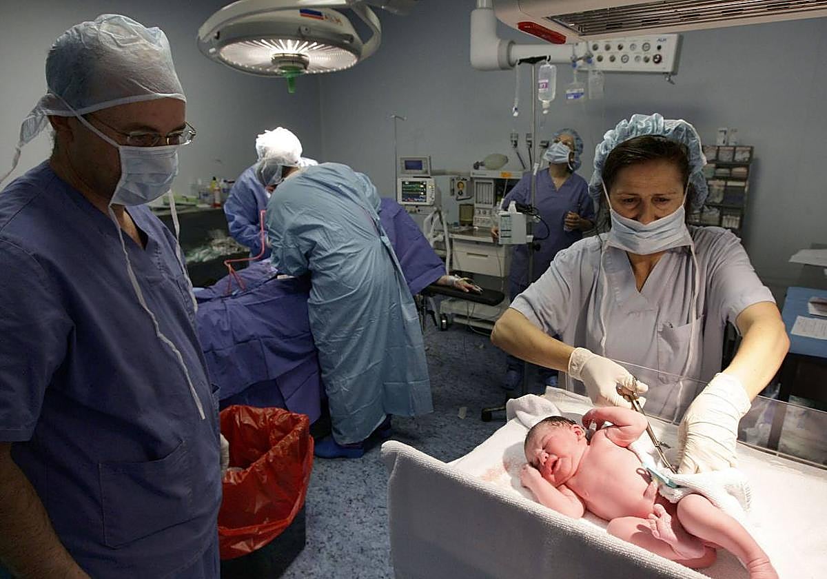 Una matrona atiende a un recién nacido en la maternidad de un hospital.
