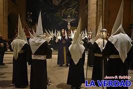 Los cofrades del Silencio rezan ante el Cristo al iniciar la procesión