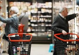 Dos clientes comparan precios mientras hacen su compra.