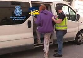 Un agente de la Policía Nacional junto a una de las víctimas liberada.