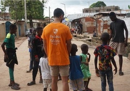 Uno de los voluntarios de Pediatría Solidaria juega con un grupo de niños en Faji Kunda, en Gambia, el pasado mes de julio.