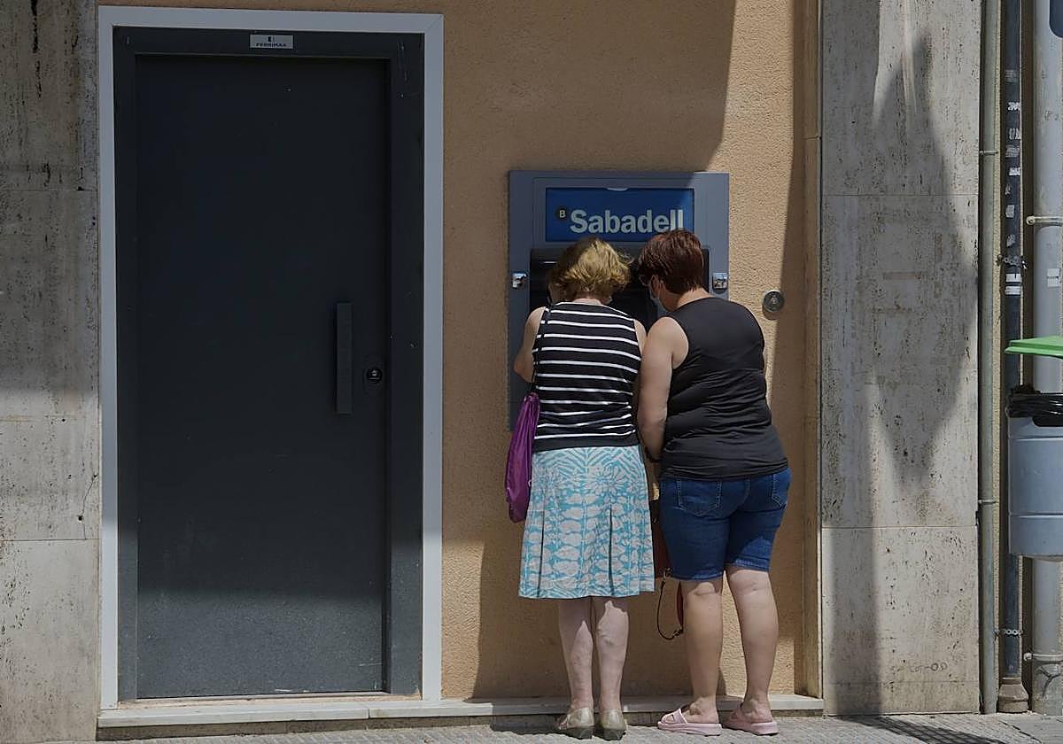Dos mujeres sacando dinero del cajero automático, en una imagen de archivo.