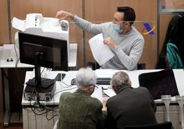 Un trabajador de la Oficina de la Agencia Tributaria atiende a dos contribuyentes, en una imagen de archivo.