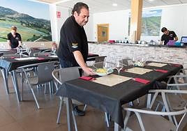 El personal de sala prepara las mesas en el comedor.