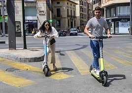 Dos jóvenes utilizan para desplazarse patinetes eléctricos alquilados, ayer en Murcia.