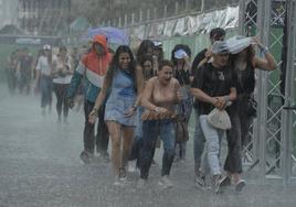 Asistentes al festival abandonando el recinto a causa de las fuertes lluvias.