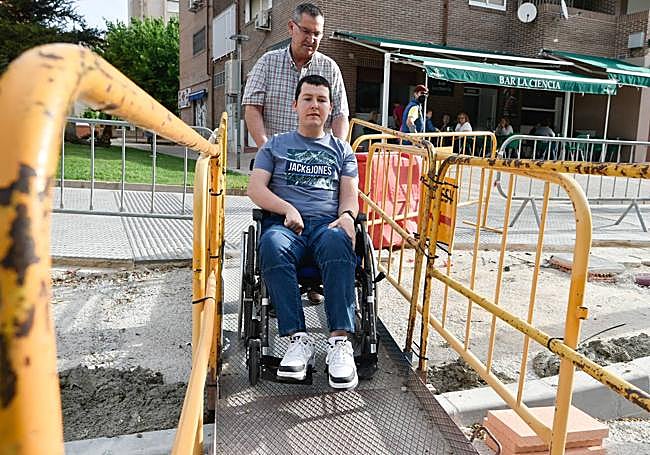Padre e hijo cruzan por la pasarela al centro de salud del Infante.