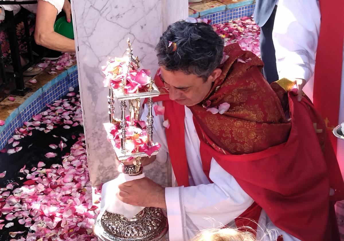 El sacerdote lleva a cabo el Baño de la Santa Cruz de Ulea.