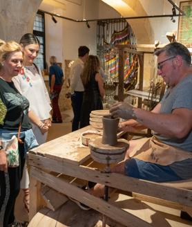 Imagen secundaria 2 - Actuación musical a las puertas de la Casa del Artesano. Visitantes contemplan los restos arqueológicos custodiados por las Madres Mercedarias. Un artesano modela una pieza de barro. 