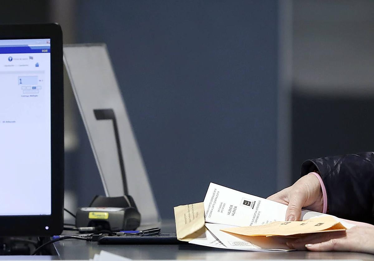 Una ciudadana recoge su voto por correo.