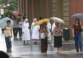 Varias personas se protegen de la lluvia en Murcia en una imagen de archivo.